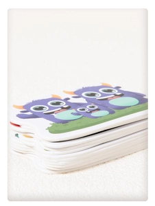 Close-up of stacked purple monster paper cards showing material thickness and print quality