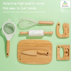 Wooden kids play kitchen set with rolling pin and whisk on mint green background