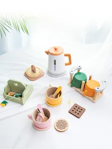 Detail of wooden tea set toys featuring white kettle, colorful cups, and organic tea bags