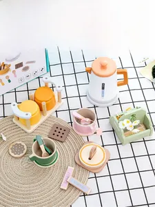 Macro detail of wooden play tea set with kettle, cups and cookies on a kitchen table