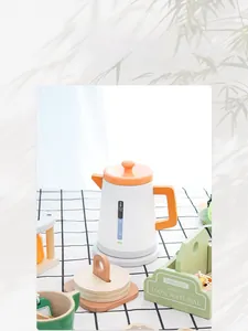 Detail of wooden tea set toys with kettle and tray on a checkered tablecloth