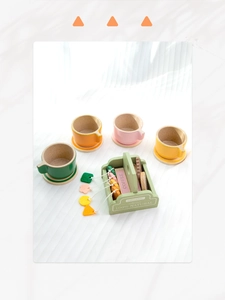 Detail view of colorful wooden play tea set with cups, basket and pretend snacks