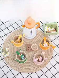 Detail of wooden tea set with colorful cups and teapot on a woven placemat