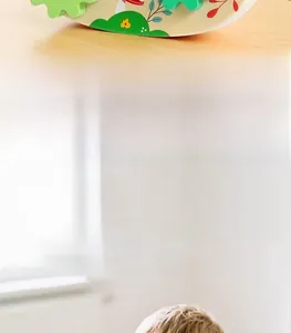 Detail eines pädagogischen Holzuhr-Spielzeugs mit bemalten Zahnrädern für Kinder
