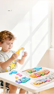 Toddler hands matching colorful wooden animal puzzles on a white table for early education