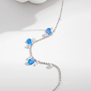 S925 silver ball chain bracelet with pear-shaped aquamarine stones on a white background