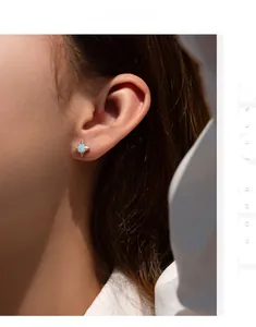 Close-up of a S925 silver star stud earring with a light blue moissanite on model