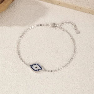 S925 sterling silver evil eye chain bracelet with blue cubic zirconia on stone surface