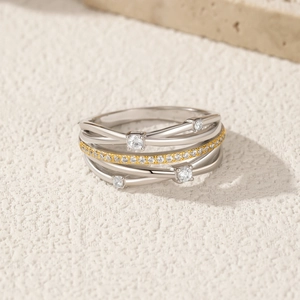 Elegant multi-layer S925 silver ring with sparkling gold crystal bands on a stone surface