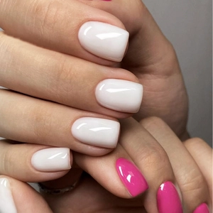 Macro shot of glossy medium-square press-on nails in cream white and bright pink finish
