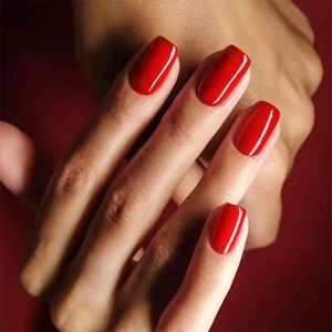 Macro shot of glossy bright red square-round press-on nails with a minimalist finish