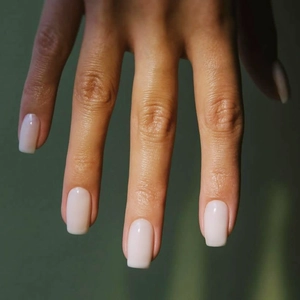Detailed view of short square press-on nails in milky white and translucent pink finish