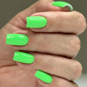 Close-up of vibrant neon green long square press-on nails with a high-gloss finish