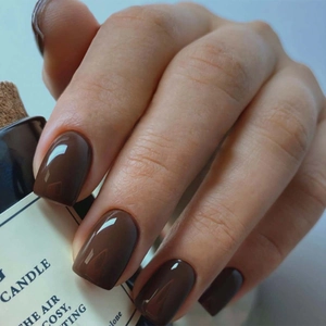Detail of glossy deep brown square-round press-on nails with a smooth polished finish