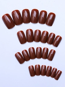 Detailed view of glossy chocolate brown square press-on nails set on white background