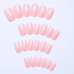Macro detail of 24-piece set of pink translucent mid-length rectangular press-on nails