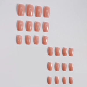 Macro display of 24-piece glossy nude pink square-oval press-on nail set on white background