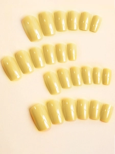 Detail of 24 pieces solid cream yellow glossy medium square press-on nails in various sizes