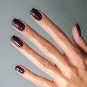 Macro shot of deep plum purple glossy finish on medium square press-on nails