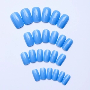 Macro view of sky blue press-on nails with high-gloss finish in 24 different sizes