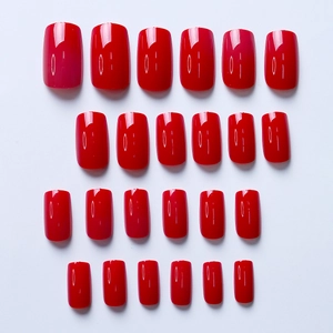 Macro detail of 24-piece medium-length square red press-on nails with glossy finish