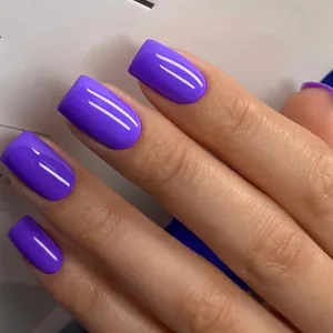 Macro shot of glossy purple square press-on nails with mirror finish on model hand