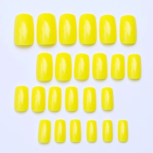 Flat lay of 24 pieces bright yellow medium square press-on nails with glossy finish
