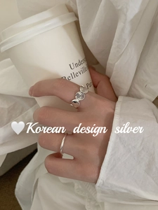 Close-up of S925 sterling silver retro oval heart link rings worn on hand in a cozy scene