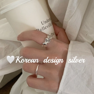 Minimalist S925 sterling silver vintage oval graffiti rings on a textured hand-held cup