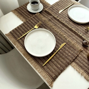 Striped paper and jute woven placemat with natural fringe edge for dining table decor
