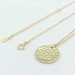 Close-up of gold-plated S925 sterling silver hammered round pendant and lobster clasp