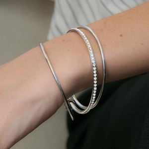 Detailed macro view of a three-piece silver zircon bangle set worn on a model's wrist