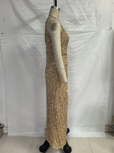 Detailed view of gold sequin dress fabric texture and side slit design on a mannequin