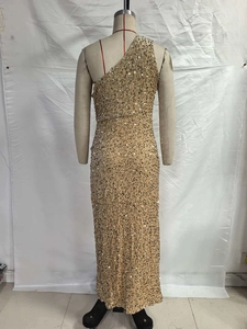 Detail of champagne gold sequined fabric on a sexy one-shoulder long evening dress