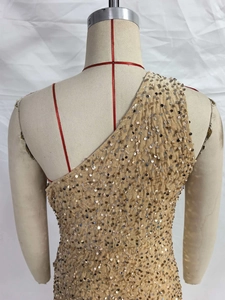 Detailed view of the sparkling sequin texture and elegant one-shoulder draped design