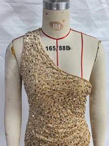 Detail of champagne gold sequins on a one-shoulder formal dress with shimmering finish