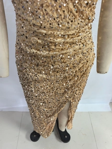 Detailed close-up of gold sequins and side slit on this slim-fit cocktail party dress
