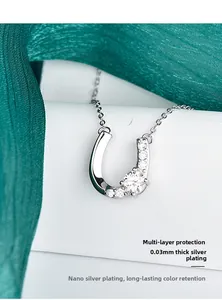 Macro-opname van hoefijzer ketting met zilveren plating en zirkoon op groene zijde
