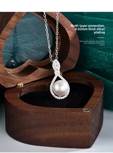 Macro view of teardrop pearl pendant with moissanite accents in walnut gift box