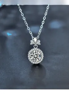 Macro detail of 3EX cut moissanite pendant with halo setting and bowknot design