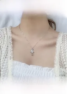 Détail du pendentif bonnet de Noël en argent avec zircons et petit grelot sur chaîne