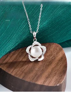 Vue macro d'un pendentif pétale en argent S925 avec perle de culture sur bois