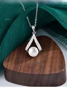 Dettaglio del pendente di perle a forma di V in argento 925 con moissanite su seta