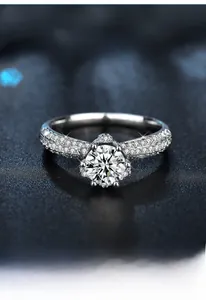 Macro shot of 925 sterling silver six-prong moissanite crown ring with pavé side stones