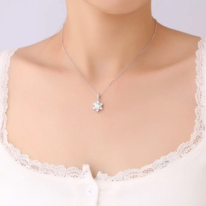 Close-up of S925 sterling silver snowflake pendant with sparkling moissanite on neck