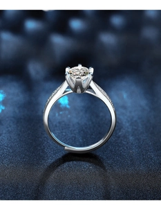 Dettaglio anello in moissanite a sei griffe con diamanti laterali e fascia regolabile