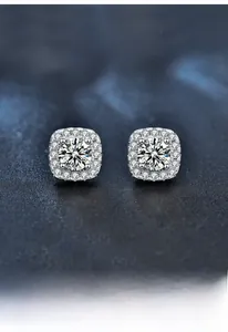 Macro view of S925 silver square halo moissanite stud earrings on blue background