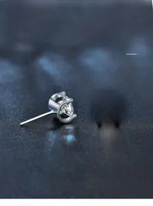 Macro shot of silver stud earring with four-prong moissanite setting and polished finish