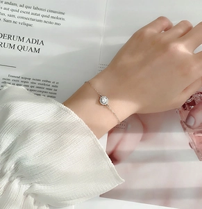 Gros plan d'un pendentif moissanite halo sur un fin bracelet en argent sterling 925