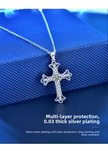 Macro shot of silver cross necklace with moissanite crystals on blue jewelry box